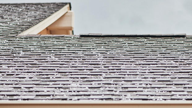 Roof shingles with large hailstones after hail storm 