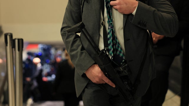 An agent holds a small automatic weapon as he guards a stairway after shots were fired during the White House Correspondents' Dinner at the Washington Hilton in Washington, D.C., on April 25, 2026. 