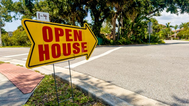 Open house sign on sidewalk by street 