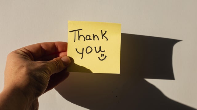 'Thank you" hand written on a yellow sticky note 