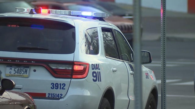 A Philadelphia police car with its lights on near the crash scene 