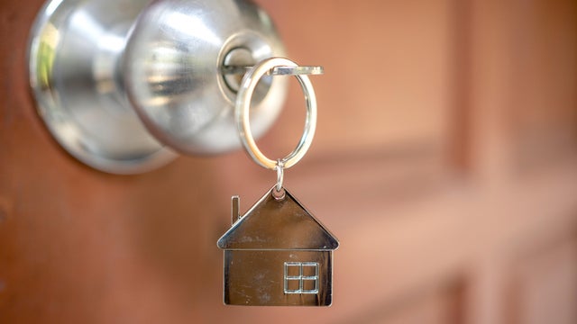 Silver house key in a door 