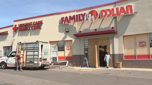 Workers board up a Family Dollar store 