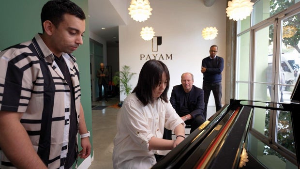 Payam teaching a student with Hans Zimmer and Bill Whitaker watching 