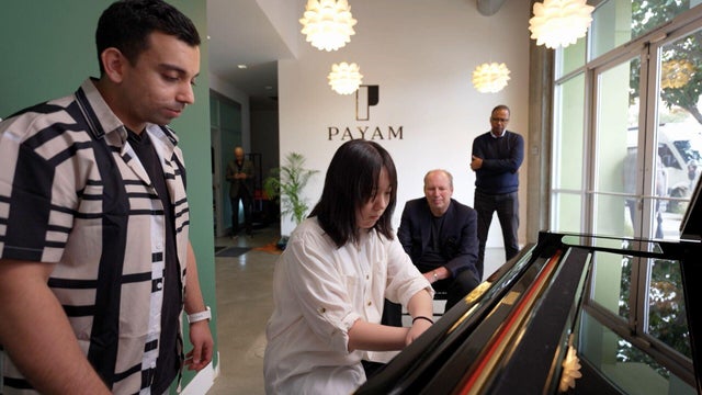 Payam teaching a student with Hans Zimmer and Bill Whitaker watching 