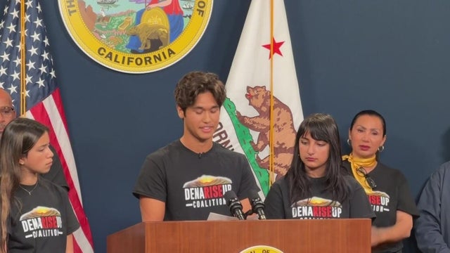 a group stand at a podium in the California State Capitol 