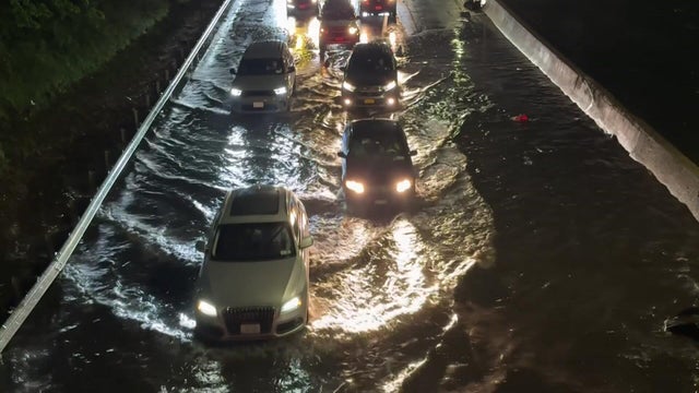 Cars drive through floodwaters on Long Island Expressway 
