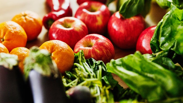 Close up shot of fresh organic fruit and vegetables on kitchen counter 