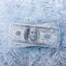 mixed image of frozen dollars in ice cube, global economic crisis and downsizing concepts 