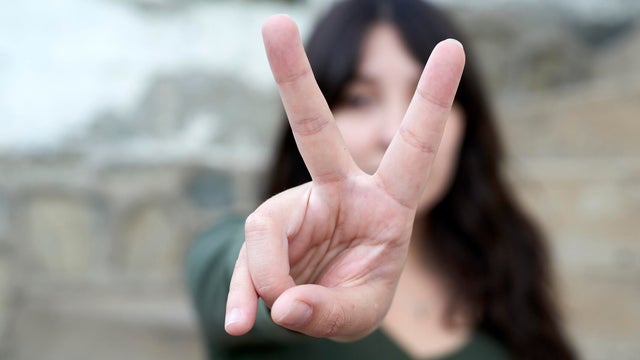 Young woman showing peace sign gesture with hand 