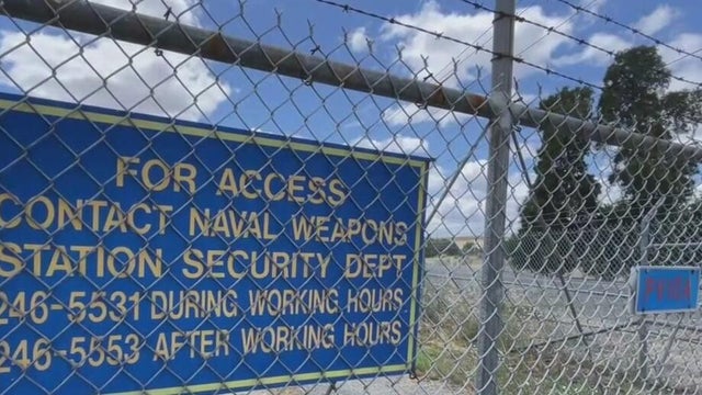 a sign behind a chainlink fence 