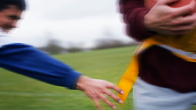 Close up of a sports player reaching for a flag to score a point in non-contact flag American football game. 