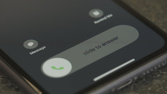 An iPhone with an incoming phone call lighting up the screen 