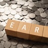 Wooden blocks with "EARN" text of concept and coins. 