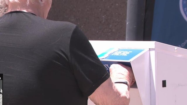 A person dropping off a ballot 