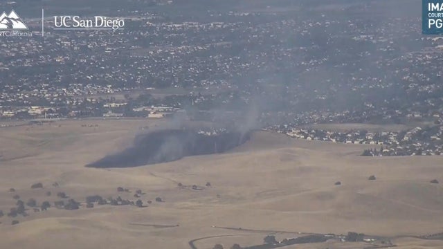 a vegetation fire seen near homes 