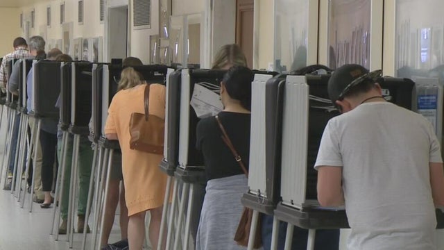 people casting ballots at voting booths 