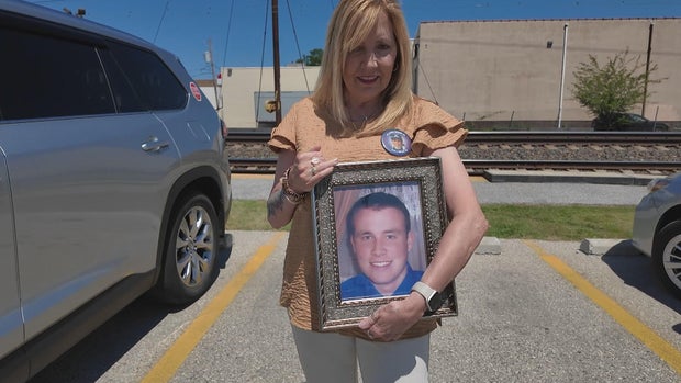 Eileen Miller holds a framed photo of her son, Paul 
