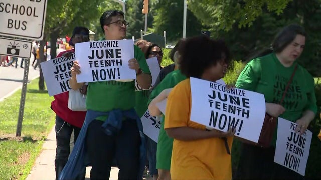 Protesters hold signs reading "recognize Juneteenth now!" 