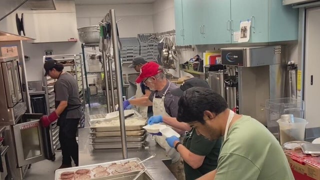 people preparing food in a commercial kitchen 