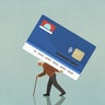 Senior man with cane walking with large credit card burden on back 