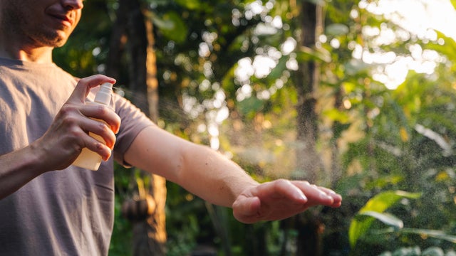 Man while applying insect repellent to hand 