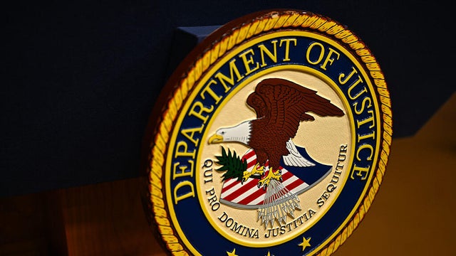 The seal of the Justice Department is displayed on a podium before a news conference at DOJ headquarters in Washington, D.C., on April 7, 2026. 