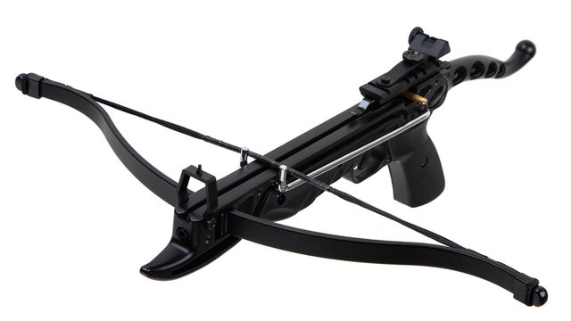 A black tactical crossbow with a sleek design, featuring a pistol grip, a rail system for attachments, and a yellow and black string, isolated on a white background. 