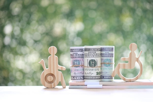 Man on wheelchair and banknotes on natural green background,Save money for prepare in future and handicapped person concept