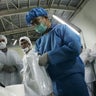 Iranian technicians look at an inspector 