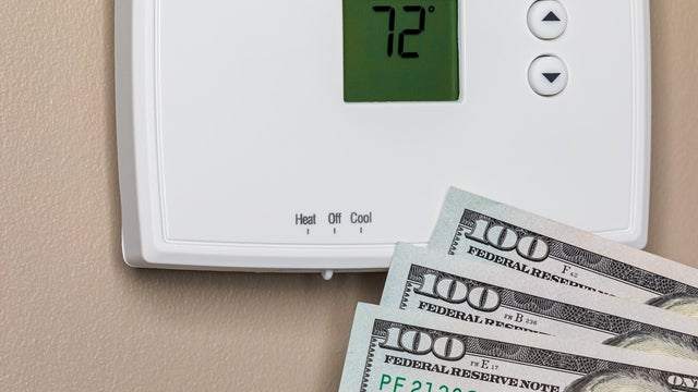 Thermostat for home furnace and air conditioner with cash money. Utility bill savings, energy cost and conservation concept 