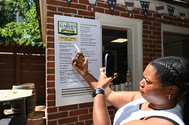 People pose for photos at City Tavern Garden 