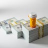Rising cost of prescription medication - Pill bottle on money 