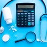 pills and medicines under a magnifying glass next to a medical stethoscope. The concept of health and responsible use of medicines, vitamins and various supplements 