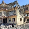 A man sits in front of a destroyed building after an attack, which the Taliban say was an airstrike carried out by Pakistan's security forces, in Samkani District 