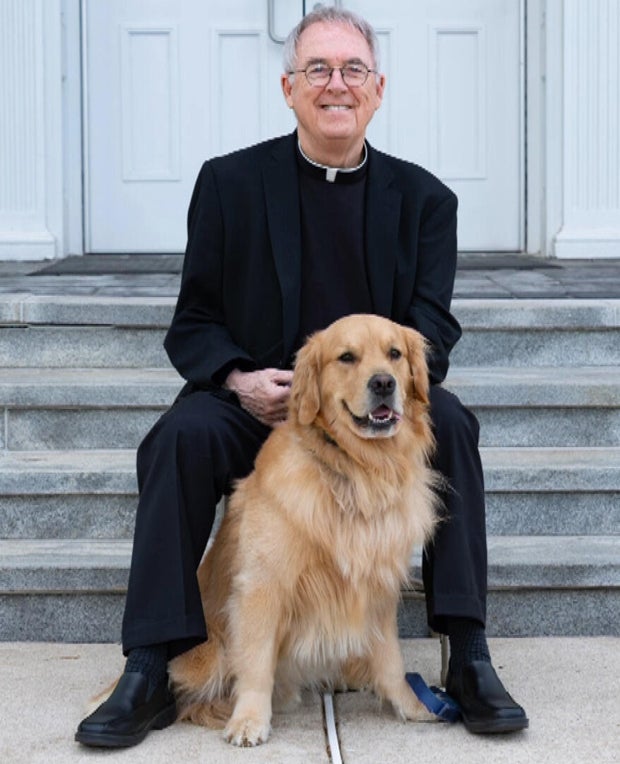 Father Murphy on the steps of the church with his golden retriever, Blaze 