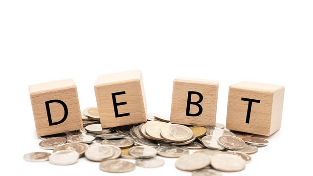 Debt Concept with Wooden Blocks and Coins. 