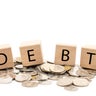 Debt Concept with Wooden Blocks and Coins. 