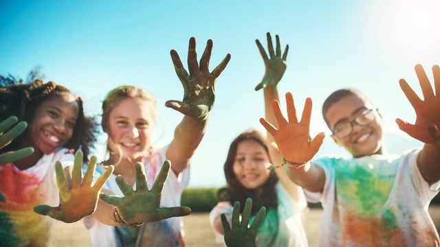 Shot of a group of teenagers having fun with colourful powder at summer camp 