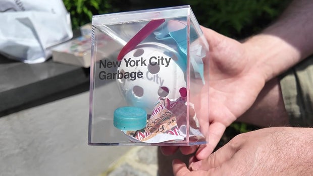 Trash in a large cube labeled "New York City Garbage." 