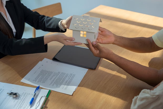 Real estate agent presenting and consult to customer to decision making sign contract agreement, home model, concerning mortgage loan offer for and house insurance.