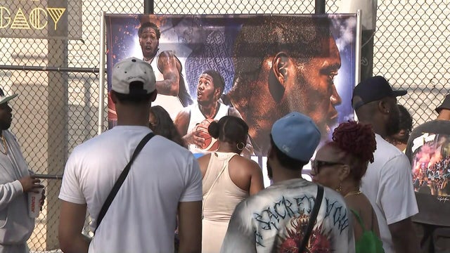 A banner with photos of Kinu Rochford at a vigil 