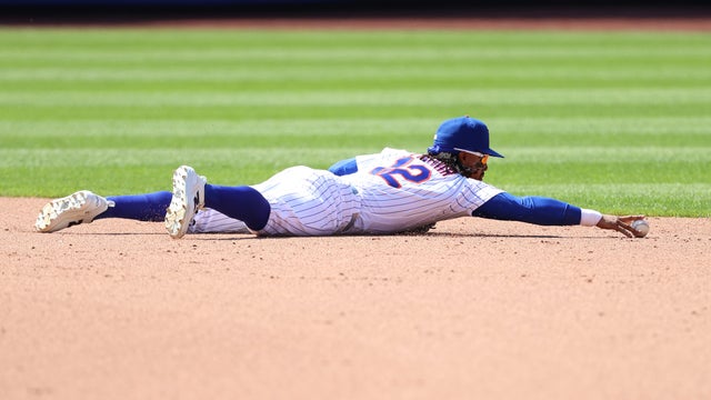 New York Mets shortstop Francisco Lindor dives for a ball hit by Boston Red Sox's Romy Gonzalez. 