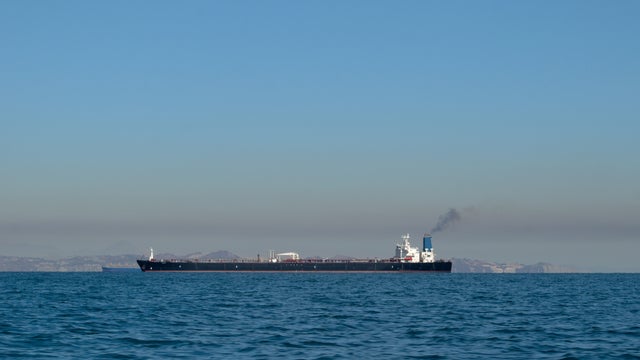 Large oil tanker ship smoking sails Strait of Hormuz, Persian Gulf, Iran 
