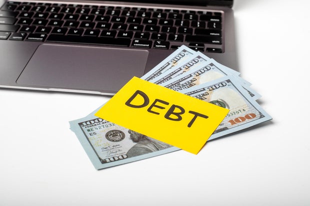 Financial debt management discussion with cash on a desk and a laptop for budgeting and planning