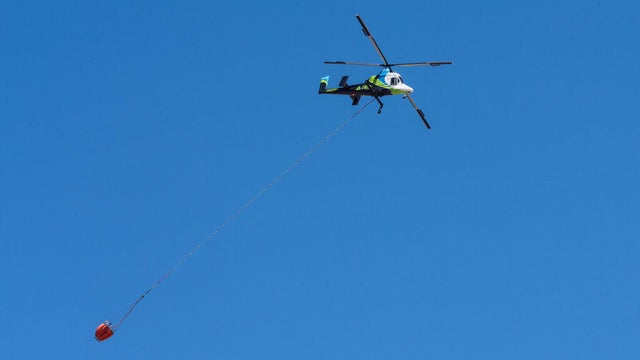 A Kaman K-Max K-1200 heavy-lift firefighting helicopter carrying a helibucket to drop water on a wildfire in Utah.. 