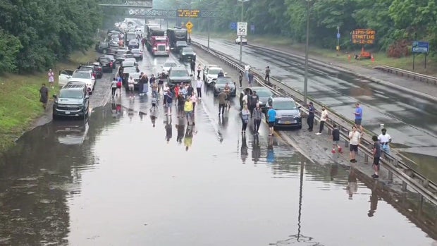 People stand in flooded road