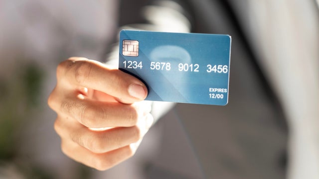 unrecognizable businessman in suit showing credit card 