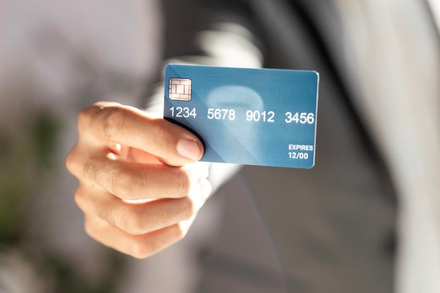 unrecognizable businessman in suit showing credit card