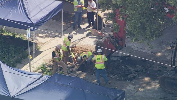 Chopper photo, crews and heavy machinery digging in dirt near a home in Olney
